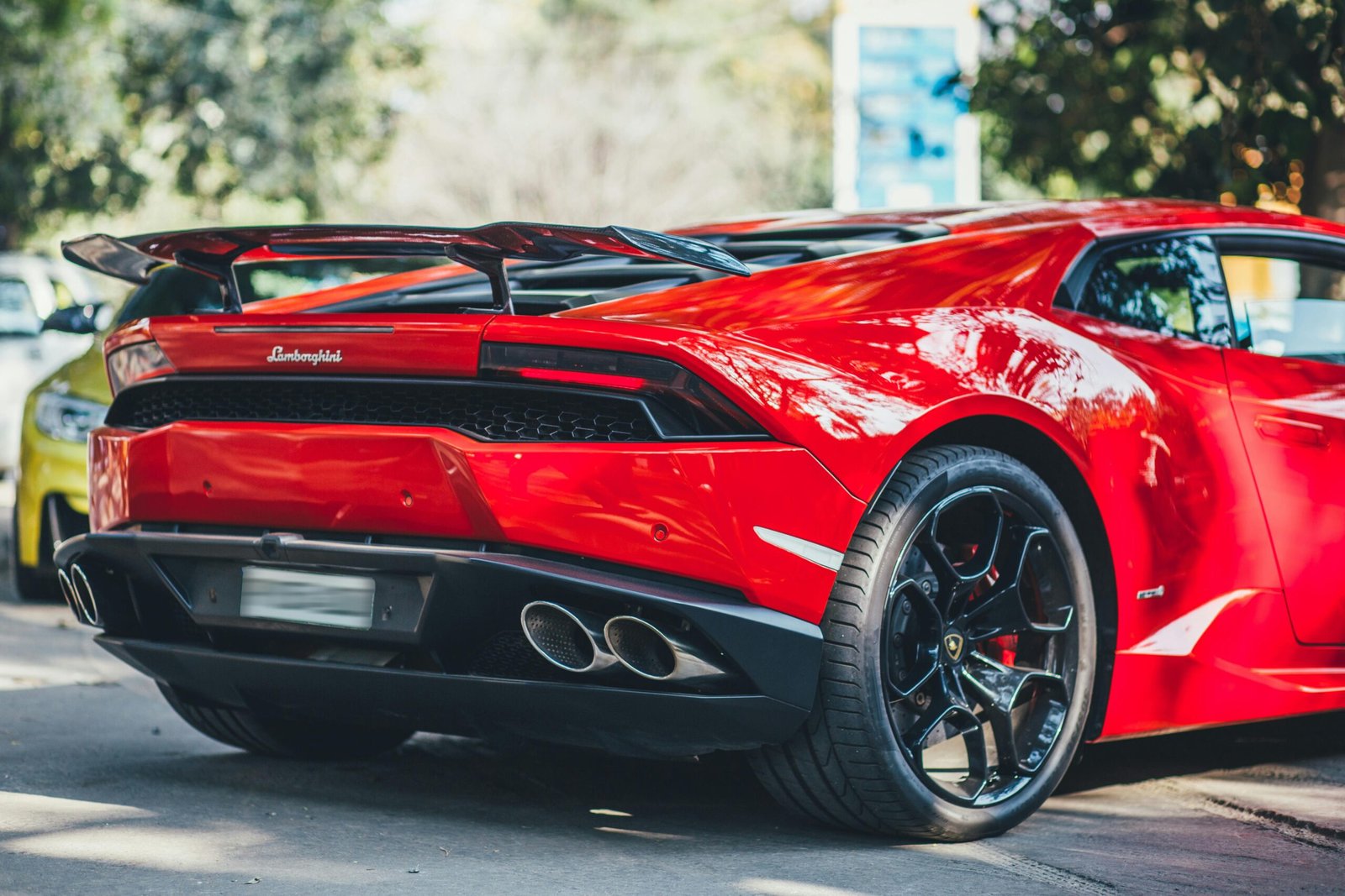 Red Lamborghini Huracan parked outdoors in New Delhi, India, showcasing luxury and style.